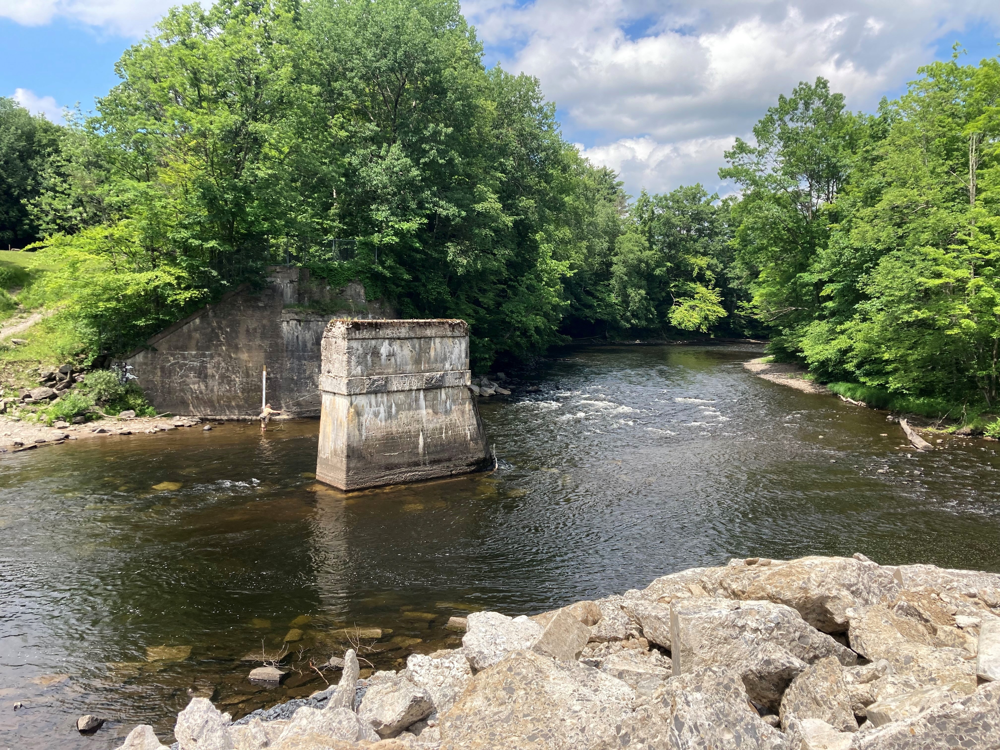 A photo of a river with concrete structures on both banks and in the center of the river.